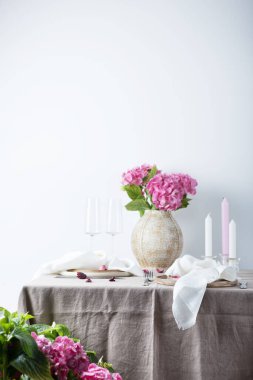 Beyaz renkli keten masa örtüsü ve ortanca ile zarif masa, seçici odak resmi