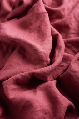 Sewing concept: stonewashed linen fabric in dark pink color clipart