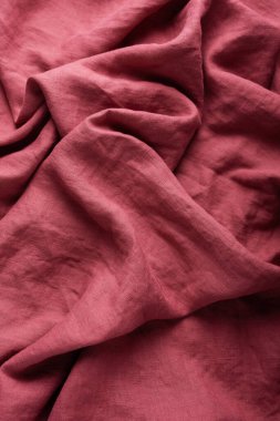 Sewing concept: stonewashed linen fabric in dark pink color clipart