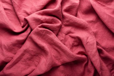 Sewing concept: stonewashed linen fabric in dark pink color clipart