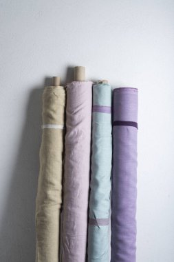 Pembe, yeşil, leylak ve açık renkli doğal keten kumaş ruloları