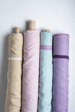 Pembe, yeşil, leylak ve açık renkli doğal keten kumaş ruloları