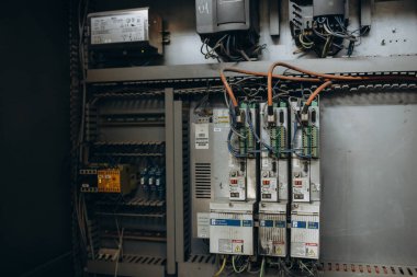 Elektrik mühendisi ana güç dağıtım panosundaki elektrik akımı voltajını kontrol etmek için dijital çoklu metre ölçüm ekipmanı kullanıyor..