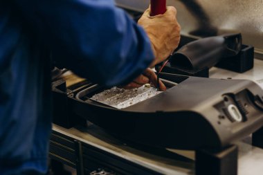 Erkek eller sokak lambası fabrikasında çalışıyor.