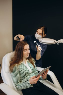 Doktor saçın yapısını teşhis ediyor. Bir trikoloğa danışmak.