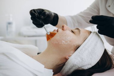 Güzellik uzmanı cildini süngerle temizliyor. Mükemmel temizlik, spa tedavisi cilt bakımı.