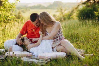 family in a field walking at sunset