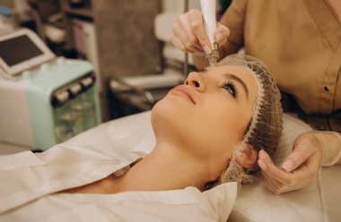 Kadının yüz hidro mikro dermabrüksiyon tedavisi gördüğü yakın plan. Kozmetik güzellik spa sliniğinde bir kadın. Hidra elektrikli süpürge. Kozmetoloji