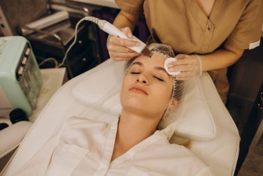 Beautiful woman receiving ultrasound cavitation facial peeling. Cosmetology and facial skin care. facial treatment, face cleansing