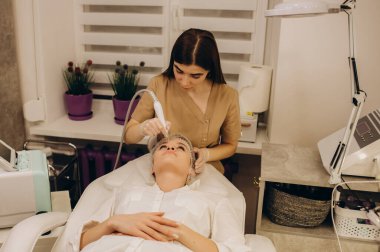 Kadının yüz hidro mikro dermabrüksiyon tedavisi gördüğü yakın plan. Kozmetik güzellik spa sliniğinde bir kadın. Hidra elektrikli süpürge. Kozmetoloji