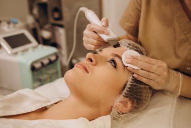 Beautiful woman receiving ultrasound cavitation facial peeling. Cosmetology and facial skin care. facial treatment, face cleansing