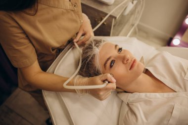 Elmas mikro dermabrüksiyon, kozmetik soyma. Güzellik salonunda mikro cilt bakımı sırasında bir kadın.