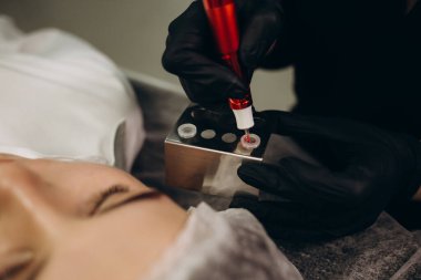 the permanent makeup artist selects the color using the color wheel