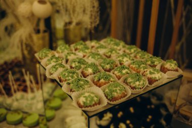 Wedding decorations. Reception. Buffet. Fruits and cheese on plates with bread in boxes. Food bar decorated by flowers and lanters.