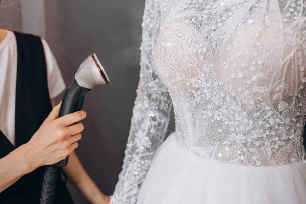Жінки Прасують Весільну Сукню Студії Допомогою Машини Ironing Весільна Концепція — стокове фото