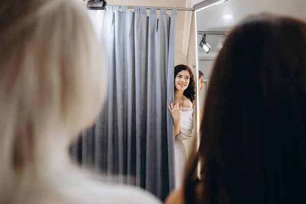 the future bride chooses a wedding dress with her friends