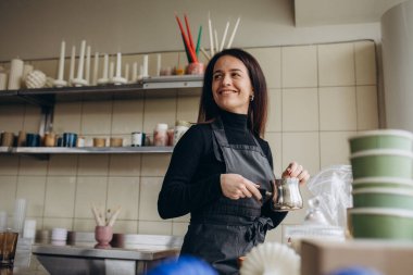 candle making A woman adds fragrance to a candle.