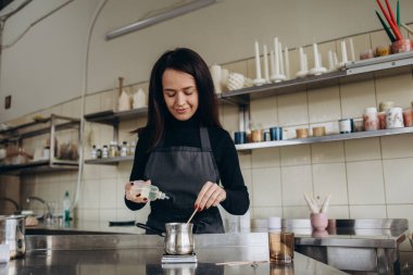 Güzel genç bayan işyeri, Venüs vücudu şeklinde aromatik mumlar üretiyor. Sanatçı kadın konsepti küçük işletme.