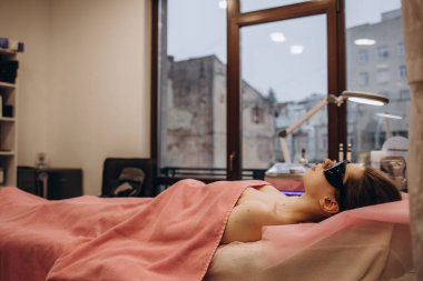 Beautiful woman waiting for armpit hair removal . Laser epilation treatment, at clinic.