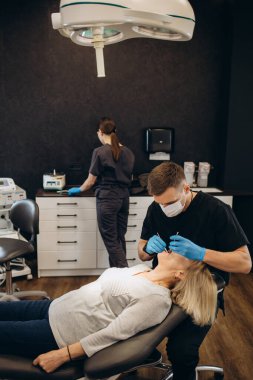 Olgun erkek diş hekimi diş check-up klinik diş hekimliği işgal tedavi tıbbi sanayi sağlık insanlar sigorta sahip onun yaşlı hasta kadın kıdemli ziyaret dişçi ile çalışma