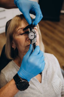 Estetik cerrahi konsültasyonunda yaşla ilgili kırışıklıkların ortadan kaldırılmasıyla ilgili yaşlı bir kadın. Gubo-chin kıvrılır, ağzın kenarları aşağı iner. Yüzün alt üçte birinin düzeltilmesi.