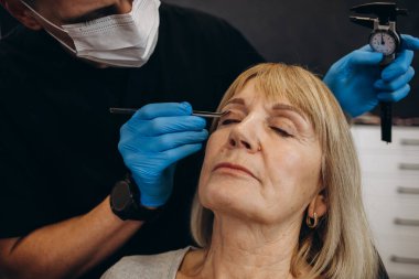 Plastik cerrahi kavramı. Eller erkek yüz gri arka plan üzerinde işaretleme