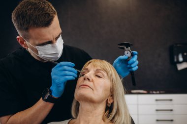 Plastik cerrahi kavramı. Eller erkek yüz gri arka plan üzerinde işaretleme