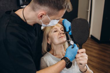 an older woman at an appointment with a plastic surgeon. skin rejuvenation concept