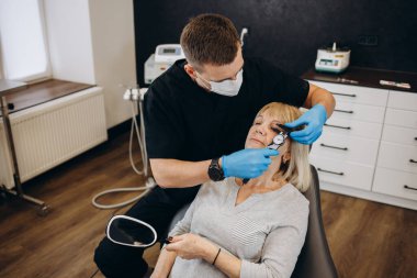 an older woman at an appointment with a plastic surgeon. skin rejuvenation concept