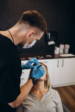 Plastik cerrahi kavramı. Eller erkek yüz gri arka plan üzerinde işaretleme