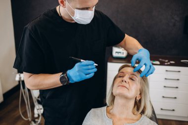 Cerrah el plastik işlem için kadın yüzü çizim izleri