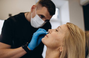 Plastik cerrahi kavramı. Eller erkek yüz gri arka plan üzerinde işaretleme