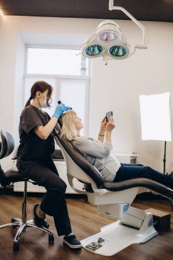 Saç ve kafa derisinin mikroskobik incelemesi için teşhis kompleksi. Bir trichologist yaşlı bir kadını muayene eder.