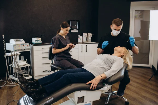 Diş ofiste operasyondaki kadın kıdemli. Diş hekimi asistanı incelenmesi ile Diş implantları