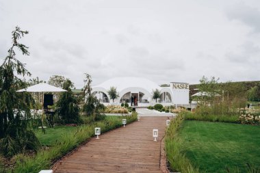 Doğada bir düğün töreni için kemeri çiçekler ve kumaşla süslemek..