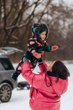 Mutlu anne küçük kızını kış günü kusar. Mutlu, neşeli bir aile