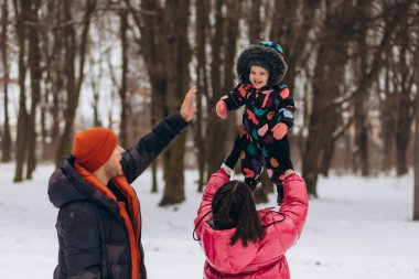 Mutlu anne küçük kızını kış günü kusar. Mutlu, neşeli bir aile