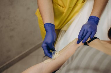 Güzellik salonunda kadın ellerine parafin tedavisi uygulamak.