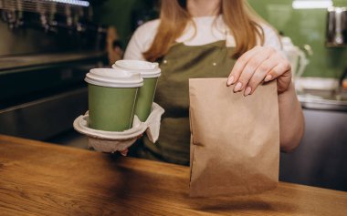 hot black coffee cup and dessert paper bag waiting for customer on counter in modern cafe coffee shop, food delivery, cafe restaurant, takeaway food, small business owner, food and drink concept