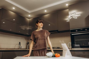 Young mother with her little daughter cooking at kitchen.