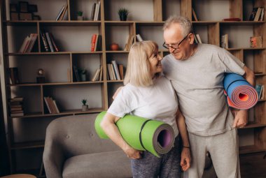 Üst düzey iki eğitim fitness evde yapıyor. Fitness yoga halı dururken. Sağlıklı yaşam konsepti.