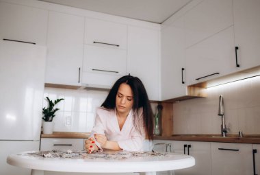 Yapboz yapan genç bir kadına yaklaş.