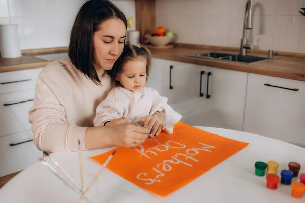 Mother's Day. the daughter draws a poster for her mother
