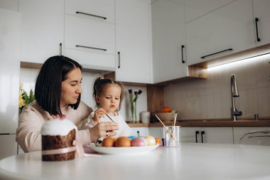 Anne ve kızı evde paskalya yumurtası boyarlar.