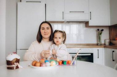 Anne ve kızı evde paskalya yumurtası boyarlar.