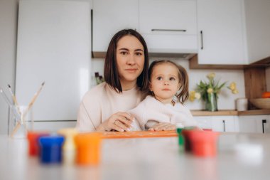 Anneler Günün kutlu olsun. Çocuk kızı annesini tebrik eder ve ona çiçek laleleri ve kartpostal verir..