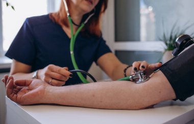 Yaşlı adamın kan basıncı ölçme doktor