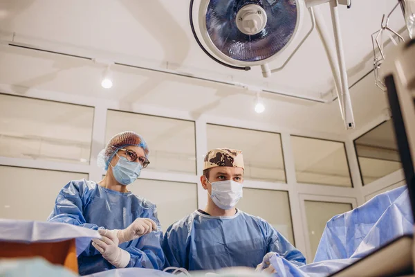 Koruyucu Maske Takan Kendine Güvenen Bir Cerrah Hastaya Bakıyor Ameliyat — Stok fotoğraf
