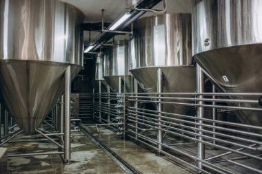 Bira fabrikasındaki tanklar. Bira tanklarında mayalanma ve bira mayalanması. Modern bira fabrikası. Depo için büyük çelik tanklar. Kamera görüntüsü baştan aşağı