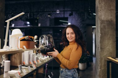 Elektronik mağazasında bir kadın kurutma makinesi seçiyor..